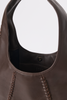 [color: chocolate leather] Close-up of a dark brown leather shoulder bag showing the interior lining, a small gold-tone logo stud, and braided strap attachments against a light gray background.