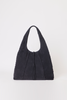 [color: navy suede] A dark navy blue suede hobo bag with braided trim and a tassel detail, photographed against a plain light gray background.