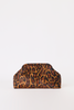 [color:cheetah] A leopard print clutch bag with a structured top handle, featuring a brown and black animal pattern on a tan background, set against a plain white studio backdrop.