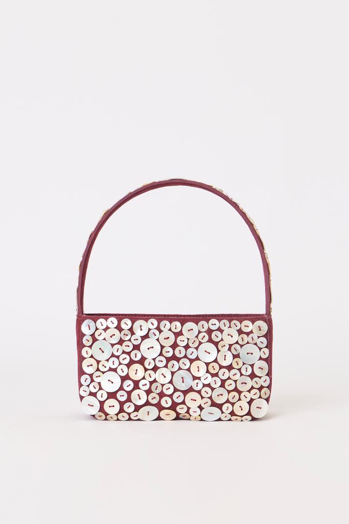 [color:burgundy] A burgundy leather handbag covered in white and cream buttons, featuring a matching burgundy top handle, set against a plain white background.