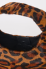Close-up of a leopard-print handbag with a black faux-leather trim and a black interior lining, set against a plain white background.