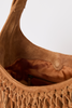 [color: WHISKEY SUEDE] Close-up of the interior of a tan suede shoulder bag with fringe trim and a zippered pocket, set against a plain light gray background.