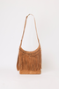 [color: WHISKEY SUEDE] A tan suede shoulder bag with a long fringe trim and a single adjustable strap, photographed against a plain white background.