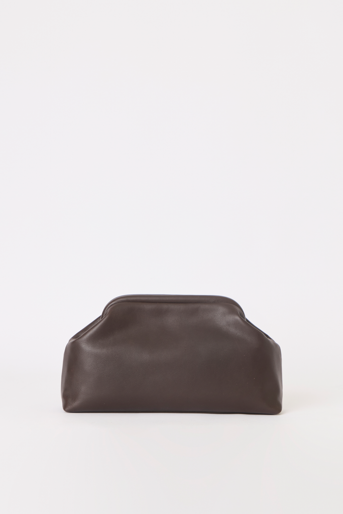 [color: chocolate leather] A dark brown leather cosmetic pouch with a rounded, slouchy shape and a top rim, photographed on a seamless white background.