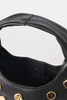 Close-up of a black leather handbag showing the interior lining and a gold-tone metal stud detail on the side against a light gray background.