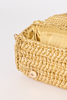 [COLOR: GOLD] Close-up of a woven straw clutch bag in a natural tan color with a gold satin lining and a gold snap button closure, set against a plain white background.