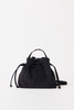 [color: navy suede] A black suede bucket bag with a top handle and shoulder strap, photographed against a plain white background.