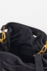 [color: navy suede] Close-up of a black bucket bag interior showing a black suede-like lining, drawstring closure, a black leather brand patch embossed with 'BITB', and gold-tone hardware.