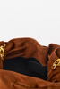 [color: whiskey suede] Close-up of a brown suede bucket bag showing the interior lining, a black interior label with 'BTB' branding, and gold-tone hardware on a white background.