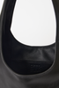 [color: black] Close-up of a black leather shoulder bag showing the interior lining with an embossed BTB London logo.