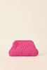 A bright pink crocheted clutch bag with a textured, woven pattern, set against a solid cream background.
