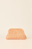 A peach-colored crocheted clutch bag with a textured, woven pattern, set against a solid cream background.