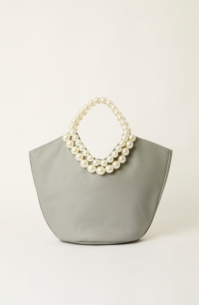 A light gray fabric tote bag with a double-strand pearl handle, photographed against a clean, off-white background.