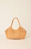 A woven straw shoulder bag in a warm tan color, featuring decorative pearl-like bead trim along the edges and a single top handle, set against a solid cream background.