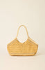 A natural straw woven shoulder bag with light tan leather handles and decorative beaded trim, shown against a solid cream background.