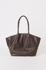 Brown leather handbag with braided handle on a white background