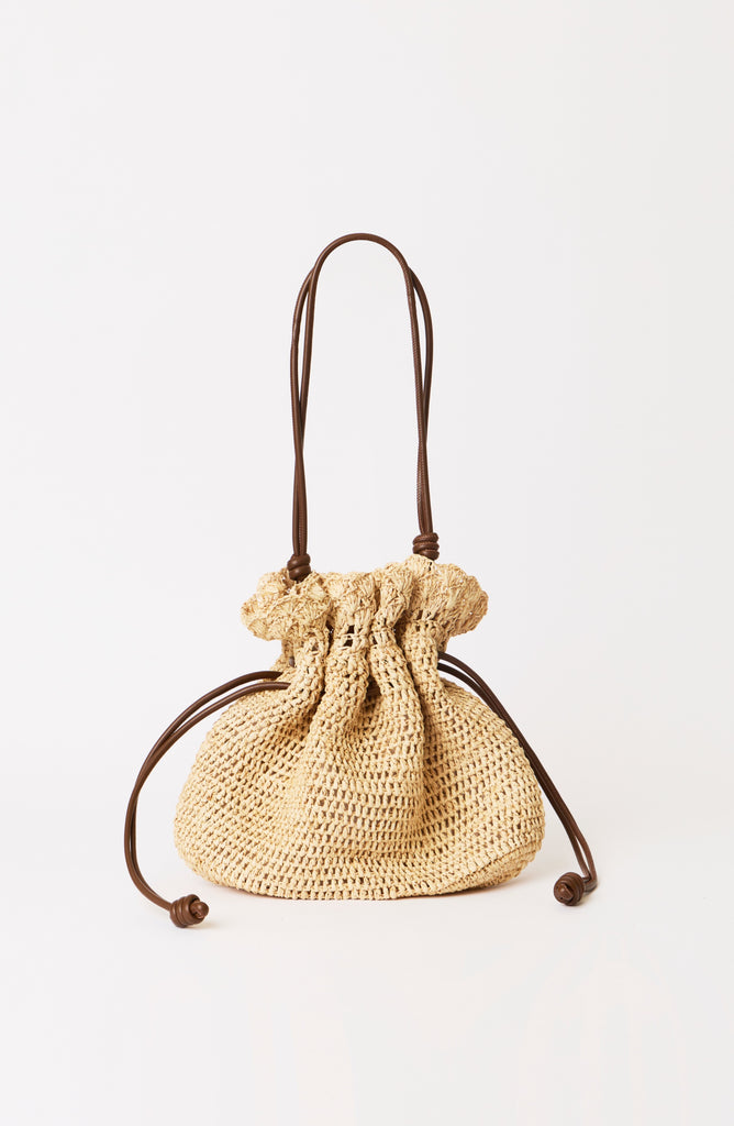 Beige woven drawstring bag on a white background